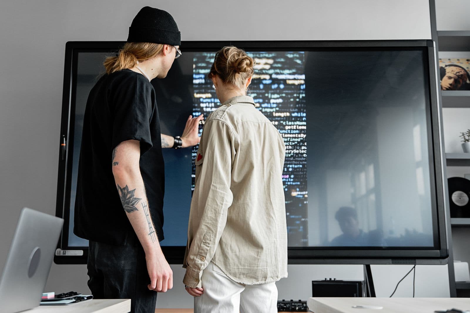 Software professionals collaborating in front of a large code display