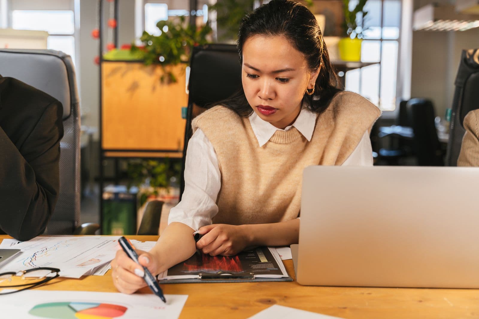 Professional working with charts and a laptop in an office